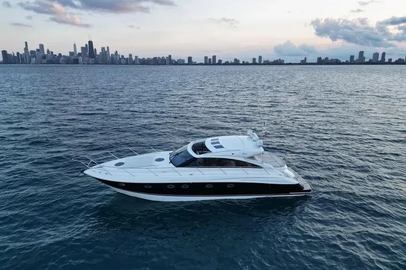 Slide: The Image of 2008 Princess V53 yacht cruising on open water with city skyline in background. - 4