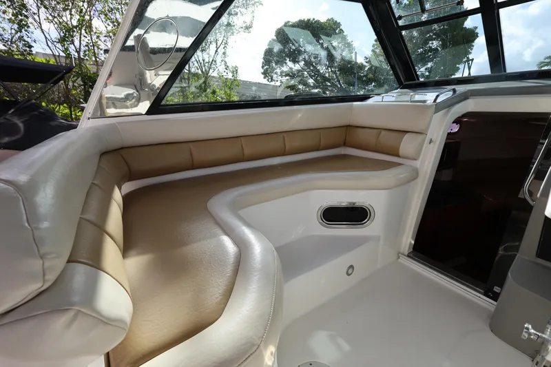 Slide: The Image of Interior of 2011 Everglades 320EX boat with beige seating and large windows. - 11