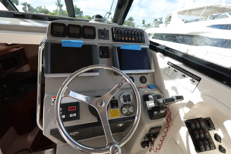 Slide: The Image of Control panel of a 2011 Everglades 320EX boat with steering wheel and navigation instruments. - 13