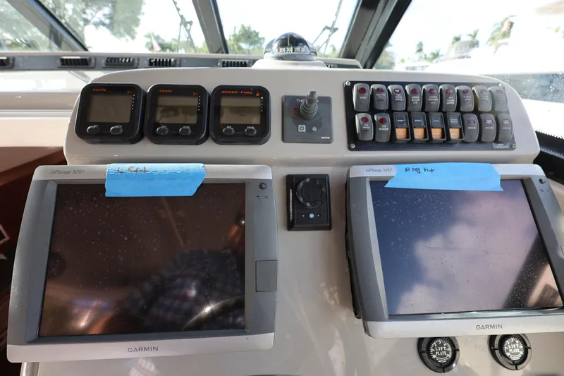 Slide: The Image of Control panel of a 2011 Everglades 320EX boat with Garmin displays and switches. - 14