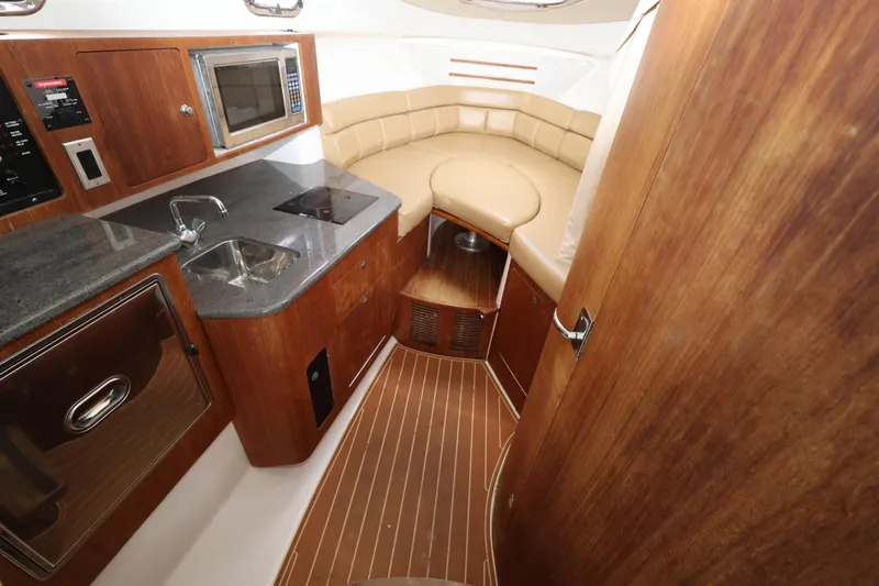 Slide: The Image of Luxurious 2011 Everglades 320EX boat interior with kitchenette and cozy seating area. - 17