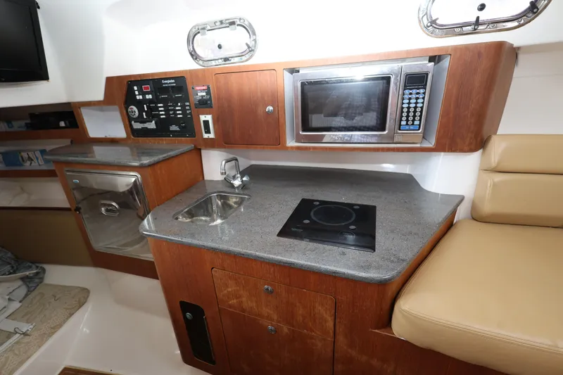 Slide: The Image of 2011 Everglades 320EX boat interior with kitchenette, microwave, and sink. - 19