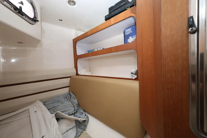 Slide: The Image of 2011 Everglades 320EX cabin interior with wooden shelves and beige seating. - 22
