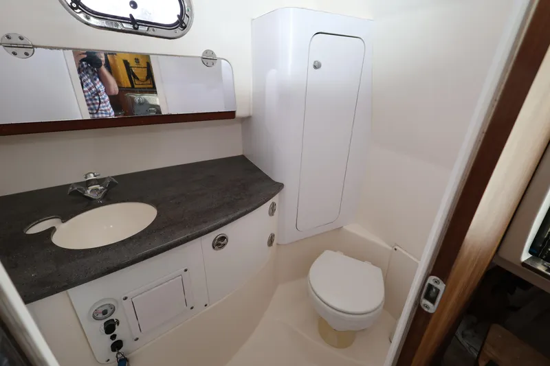 Slide: The Image of 2011 Everglades 320EX boat bathroom with sink, mirror, and toilet. - 24
