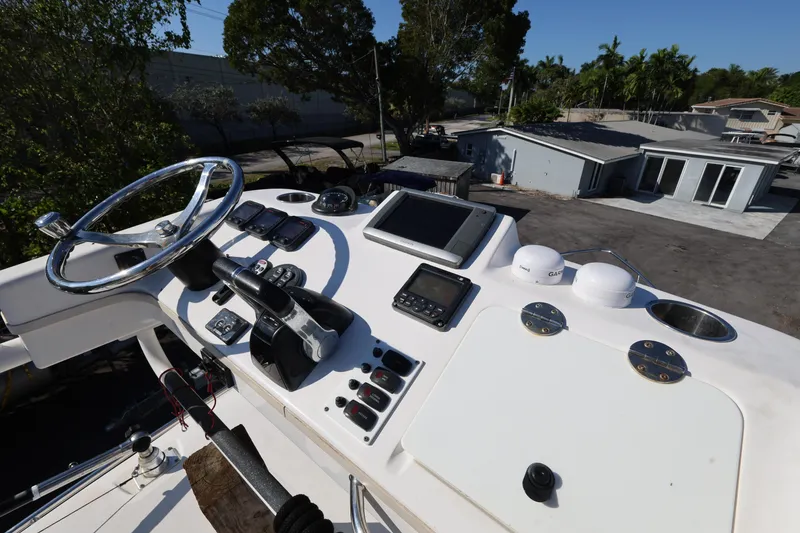Slide: The Image of Control panel of a 2011 Everglades 320EX boat with steering wheel and navigation equipment. - 26