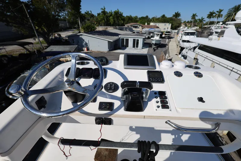 Slide: The Image of Control panel of a 2011 Everglades 320EX boat with steering wheel and navigation equipment. - 27