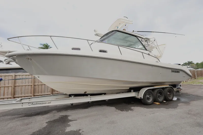 Slide: The Image of 2011 Everglades 320EX boat on a trailer, parked outdoors. - 3