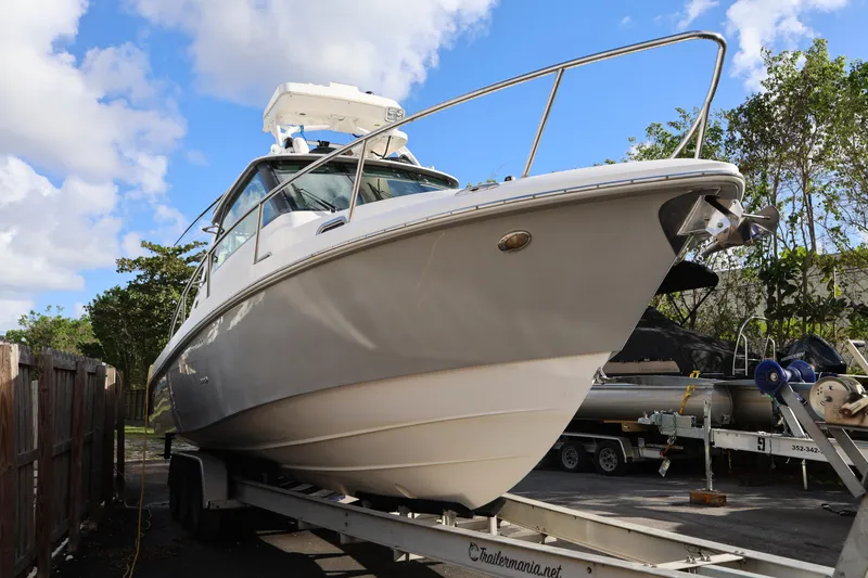 Slide: The Image of 2011 Everglades 320EX boat on trailer, parked outdoors under blue sky. - 7