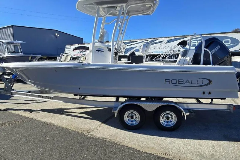 Slide: The Image of 2026 Robalo 246 Cayman boat on trailer, displayed outdoors. - 2