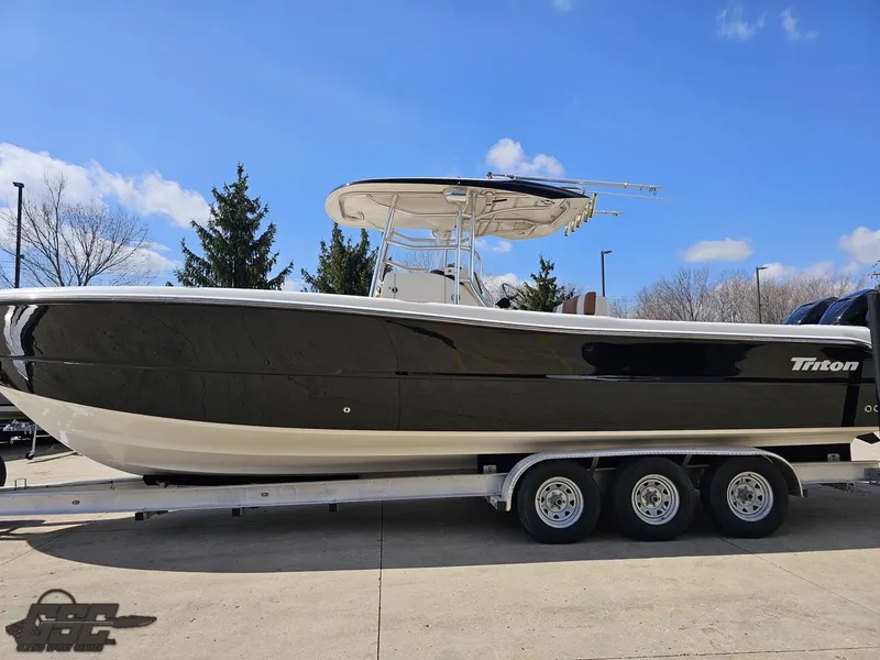 Slide: The Image of 2007 Triton 351 CC boat on a trailer under a clear blue sky. - 25