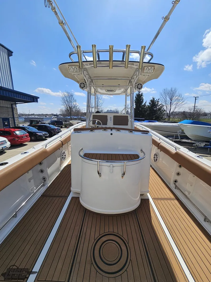 Slide: The Image of 2007 Triton 351 CC boat interior with teak flooring and fishing rod holders. - 36