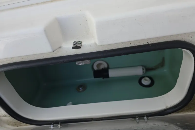 Slide: The Image of Open storage compartment in 2021 Skeeter SX240 boat, showing interior details. - 11