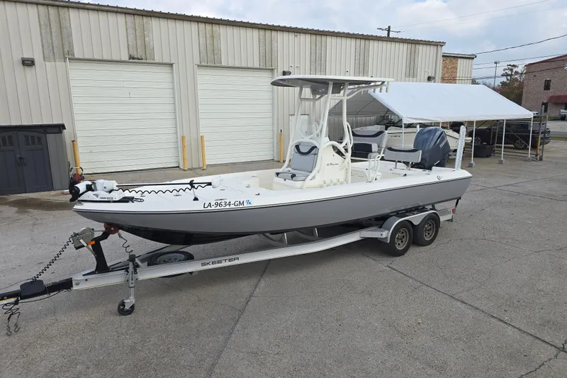 Slide: The Image of 2021 Skeeter SX240 boat on trailer, parked outside a warehouse. - 6