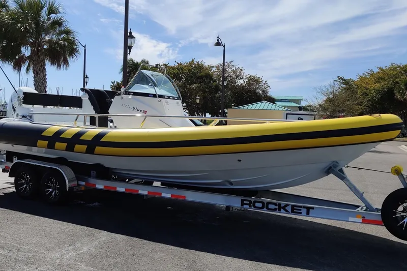 The Image of Yellow and black Arctic Blue 29 boat on a trailer, parked outdoors, 2019 model. - 0