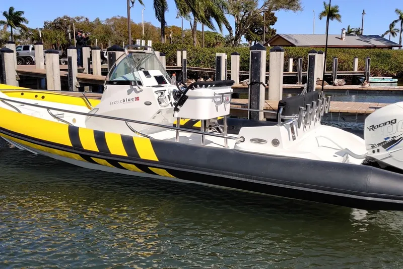 Slide: The Image of 2019 Arctic Blue 29 boat with yellow and black design docked at marina. - 3