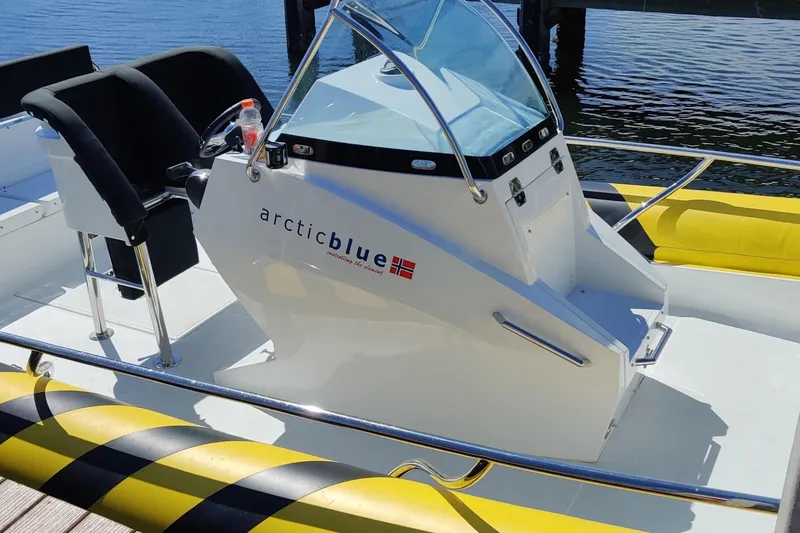 Slide: The Image of 2019 Arctic Blue 29 boat with sleek design, docked by the water. - 7