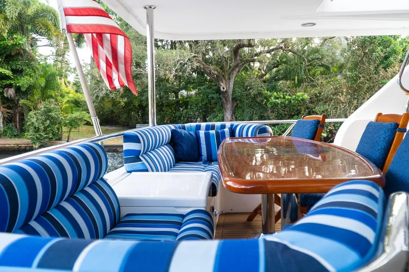 Slide: The Image of Luxurious outdoor seating on 2005 Ocean Alexander 80 Motoryacht with striped cushions and wooden table. - 6