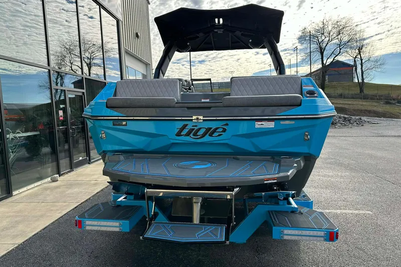 Slide: The Image of 2026 Tigé Z3 boat in vibrant blue, parked outside a modern building. - 11