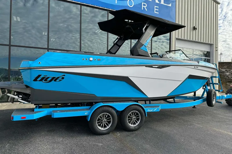 Slide: The Image of 2026 Tigé Z3 boat in blue and white on a trailer outside a store. - 5
