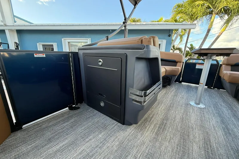 Slide: The Image of 2026 Bennington 22 M Swingback boat interior with seating and storage, under a clear sky. - 17