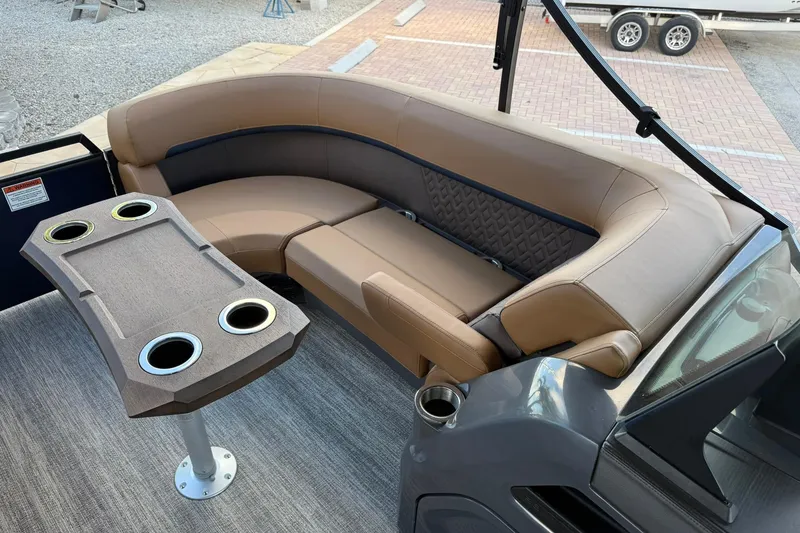 Slide: The Image of 2026 Bennington 22 M Swingback boat interior with tan seating and table with cup holders. - 22