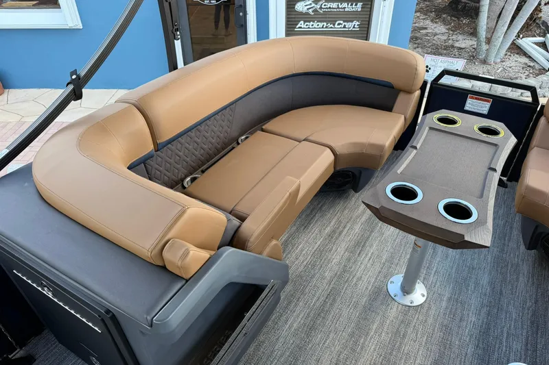 Slide: The Image of 2026 Bennington 22 M Swingback boat interior with tan seating and cupholder table. - 23