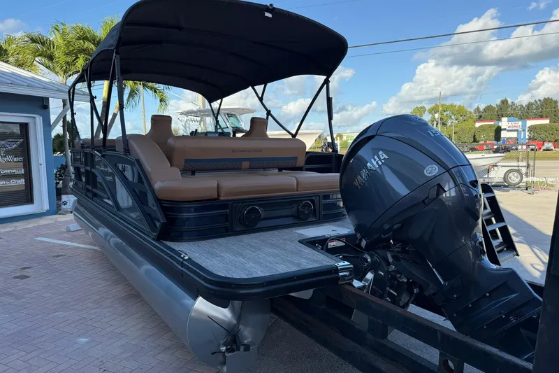 Slide: The Image of 2026 Bennington 22 M Swingback pontoon boat with Yamaha engine, docked under clear skies. - 6