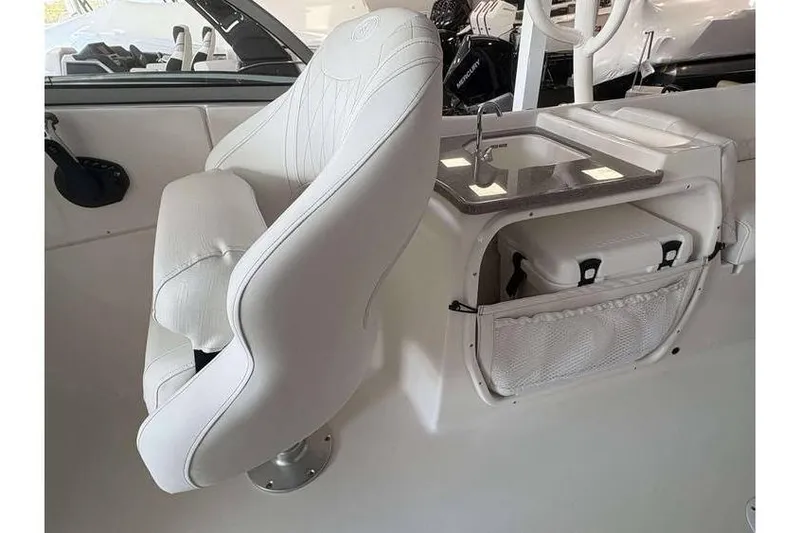 Slide: The Image of 2026 Key West 239 DFS boat interior with white seating and compact sink area. - 12