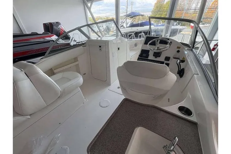 Slide: The Image of 2026 Key West 239 DFS boat interior with white seating and steering console. - 17