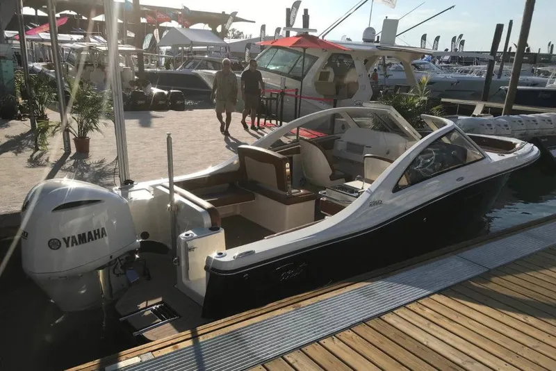 Slide: The Image of 2024 Scout 240 Dorado boat with outboard motor, docked under a clear sky. - 2
