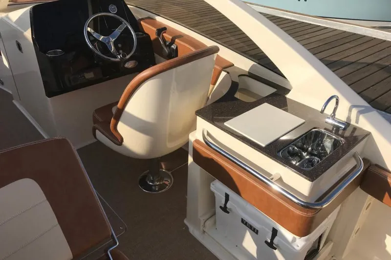 Slide: The Image of 2024 Scout 240 Dorado boat interior with beige seating and speakers. - 5