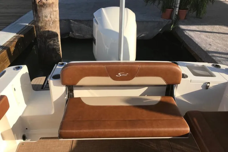 Slide: The Image of 2024 Scout 240 Dorado boat helm with steering wheel and control panel. - 7