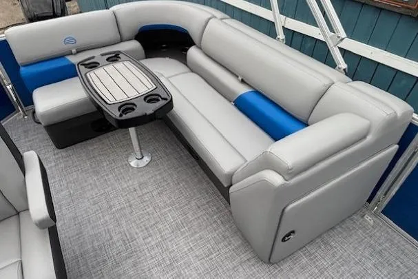 Slide: The Image of 2026 Sun Tracker Party Barge 20 DLX interior with gray and blue seating, table, and cup holders. - 10