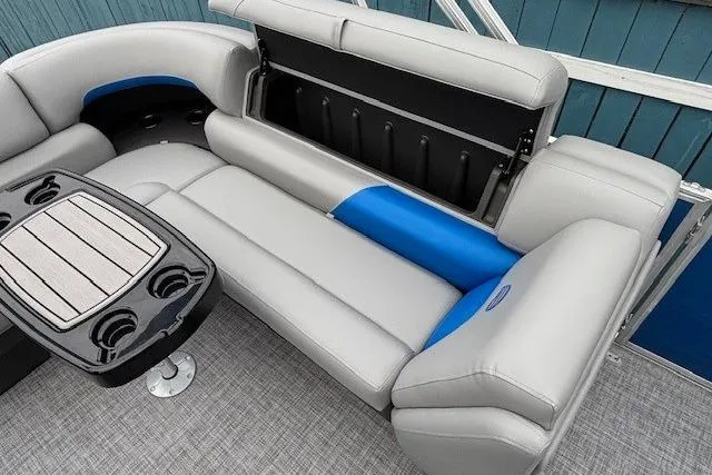 Slide: The Image of 2026 Sun Tracker Party Barge 20 DLX interior with gray and blue seating, storage, and table. - 11