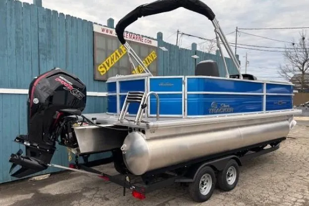 Slide: The Image of 2026 Sun Tracker Party Barge 20 DLX pontoon boat on trailer, blue and silver design. - 3