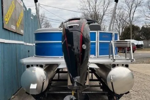 Slide: The Image of 2026 Sun Tracker Party Barge 20 DLX pontoon boat with outboard motor, docked outdoors. - 4