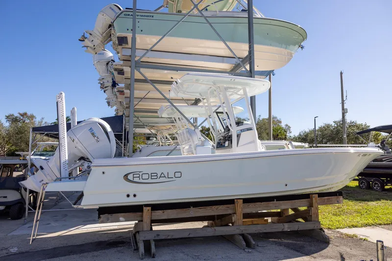 The Image of 2024 Robalo 246 Cayman boat displayed on a rack in a marina setting. - 0