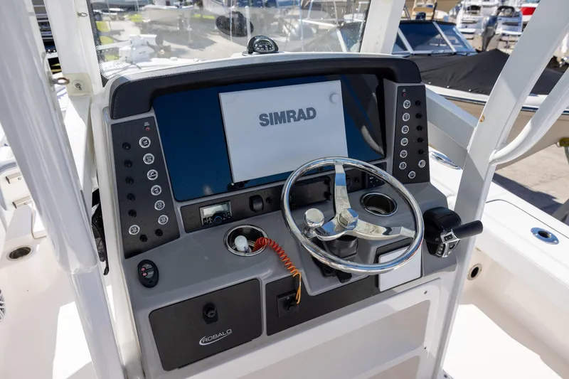 Slide: The Image of 2024 Robalo 246 Cayman boat dashboard with Simrad display and steering wheel. - 10