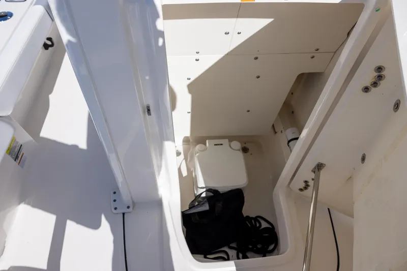 Slide: The Image of 2024 Robalo 246 Cayman boat storage compartment with portable toilet and accessories. - 15