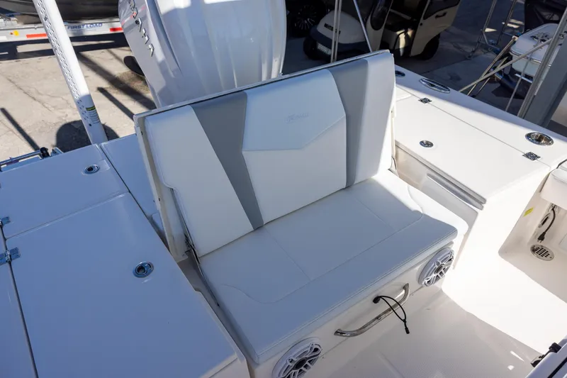 Slide: The Image of 2024 Robalo 246 Cayman boat seating area with white upholstery and integrated speakers. - 7