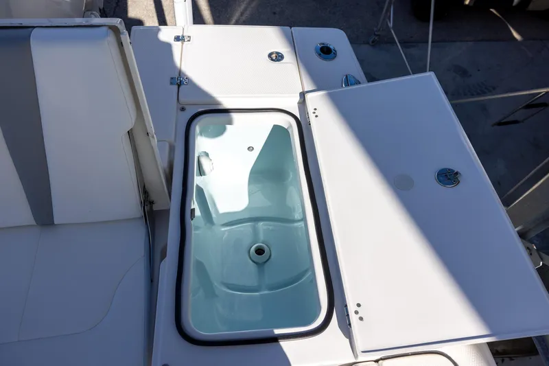 Slide: The Image of 2024 Robalo 246 Cayman boat with open storage compartment on deck. - 9