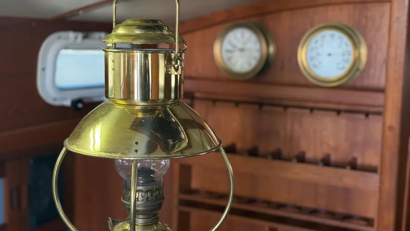 Slide: The Image of Vintage brass lantern inside 1984 Cascade 36 sailboat cabin with wooden interior and nautical instruments. - 10