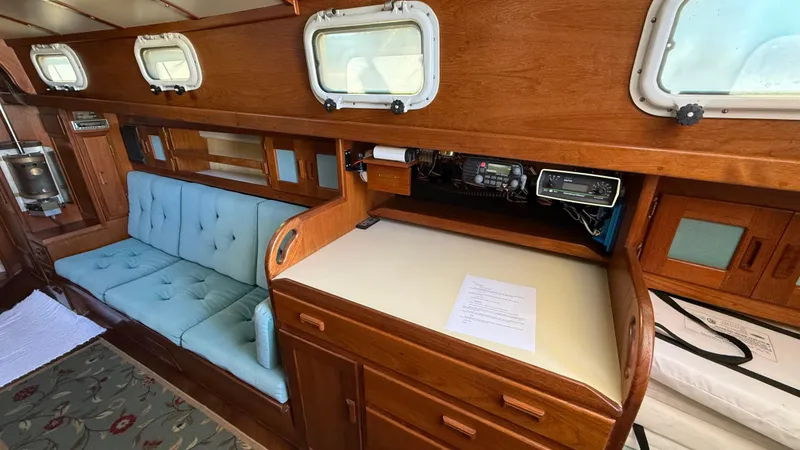 Slide: The Image of Interior of 1984 Cascade 36 sailboat with wooden cabinetry and blue cushioned seating. - 11
