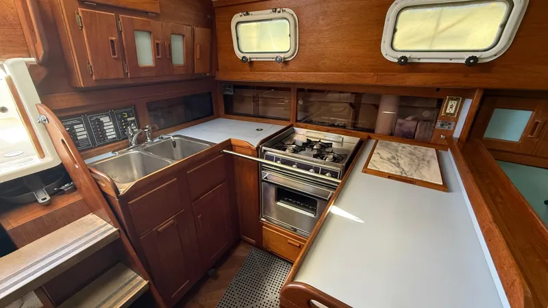Slide: The Image of 1984 Cascade 36 yacht kitchen with wood cabinetry, dual sink, stove, and countertop. - 13