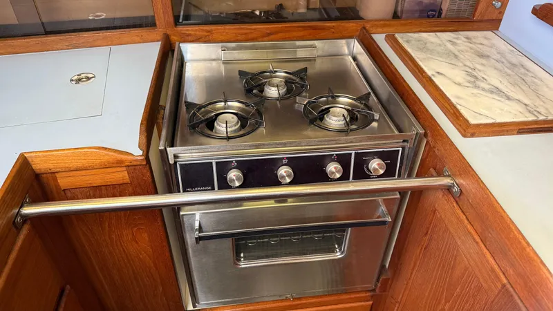 Slide: The Image of Stainless steel stove with three burners in a 1984 Cascade 36 boat kitchen. - 15