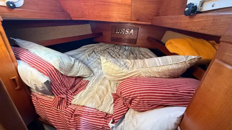 Slide: The Image of Cozy cabin bed with striped bedding in a 1984 Cascade 36 sailboat. - 17