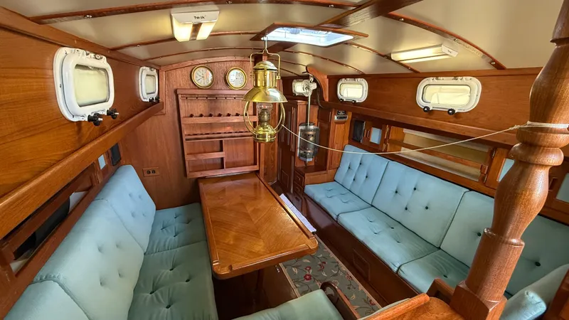 Slide: The Image of Vintage 1984 Cascade 36 yacht interior with wooden furnishings and blue cushioned seating. - 4