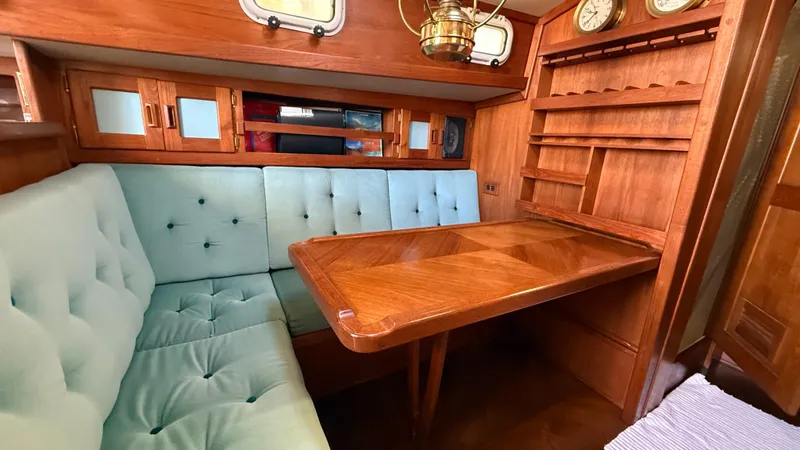 Slide: The Image of Cozy 1984 Cascade 36 yacht interior with wooden table and cushioned seating. - 6