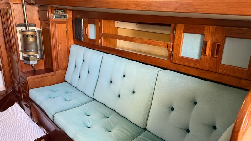Slide: The Image of Interior of 1984 Cascade 36 yacht with blue cushioned seating and wooden cabinetry. - 7