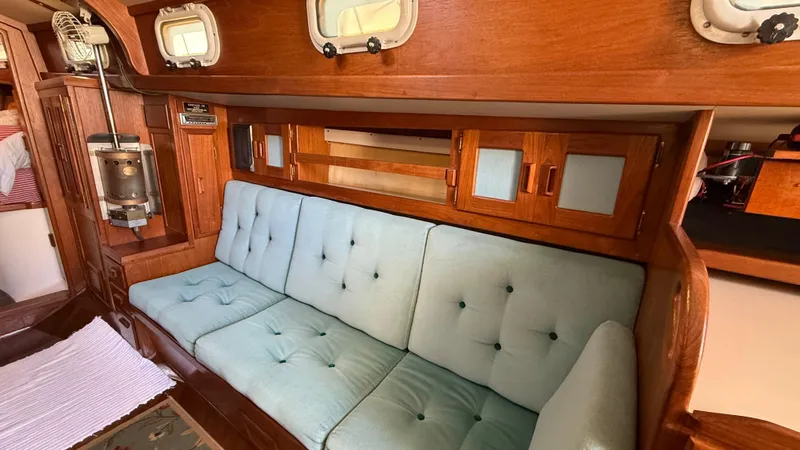 Slide: The Image of 1984 Cascade 36 yacht interior with blue cushioned seating and wooden cabinetry. - 9